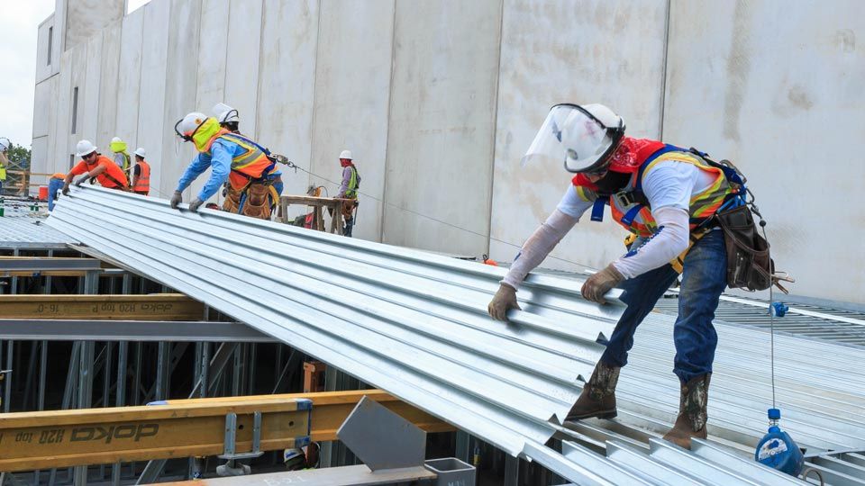 Workers placing dovetail deck on to support beams