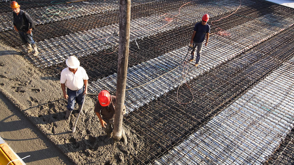 Concrete being poured onto bridge deck and rebar