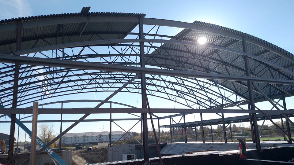 School arena under construction showing girder frame and barrel joists