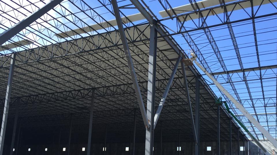 View looking up at steel deck installation on steel joists