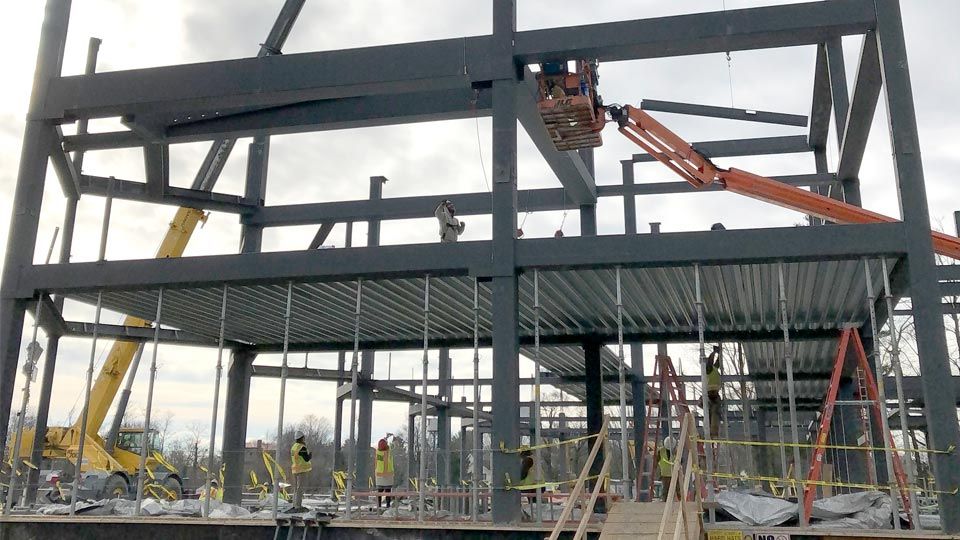 Workers on lift installing Deep-Dek® Composite on steel girders