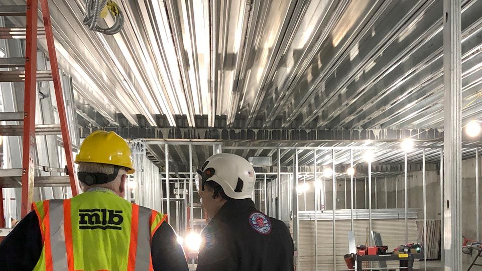 Interior construction 2 workers inspecting composite floor deck
