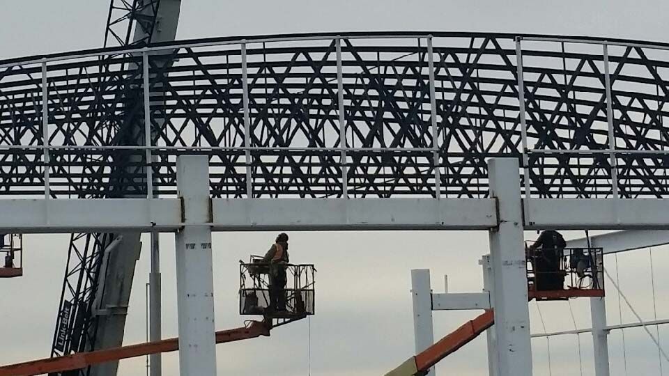 Close up of workers installing bowstring joists