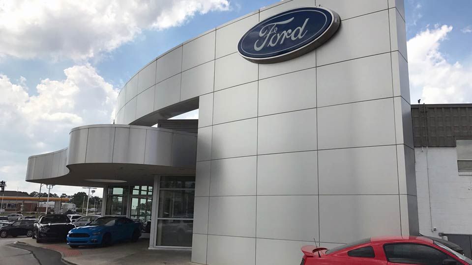 Exterior of Ford dealership with car on lot