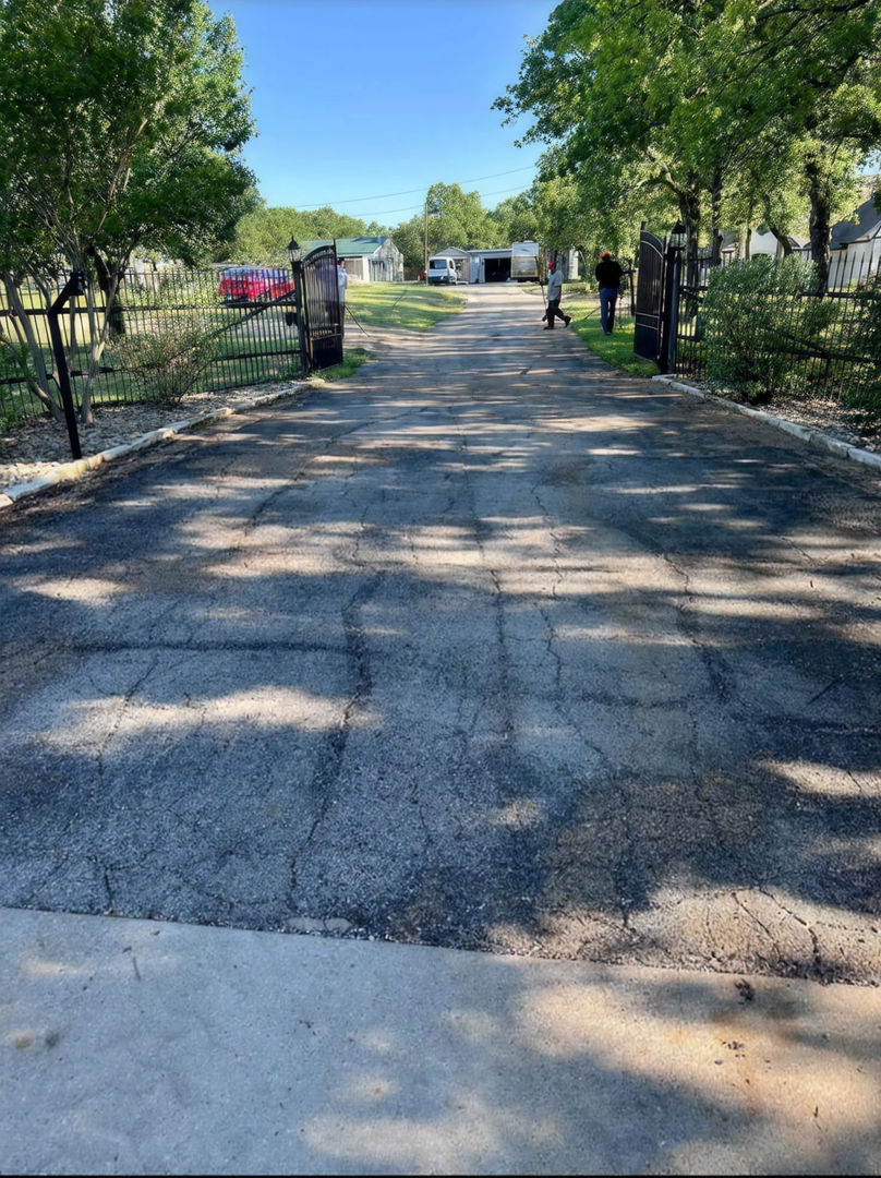 Old worn cracked blacktop surface before tar & chip renovation
