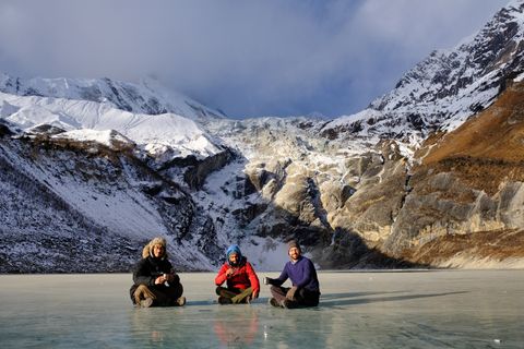 three people drinking tea on a frozen lake