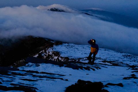 mountaineer climbing snowy mountain night