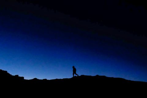 silhouette hiker standing mountain ridge night
