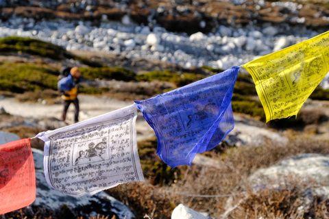 hiker behind colorful prayer flags