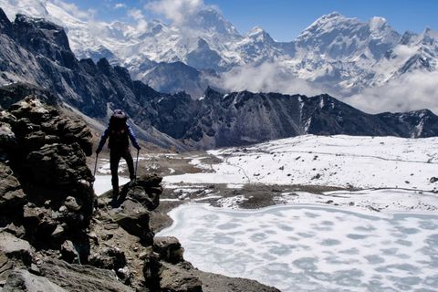 hiker on kongma pass looking at frozen lake