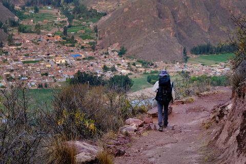 hiker descending trail to city