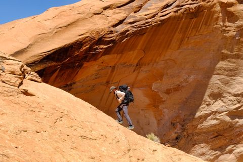 hiker climbing red rock canyon