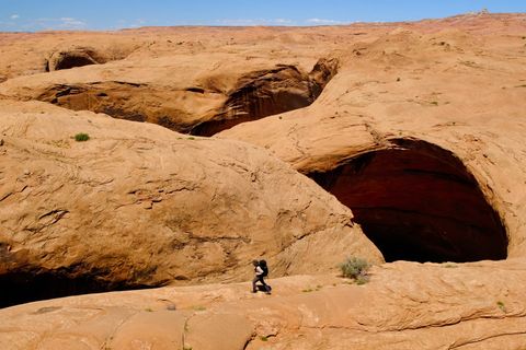 hiker walking above red rock canyon