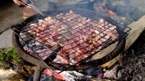 grilling pork over fire