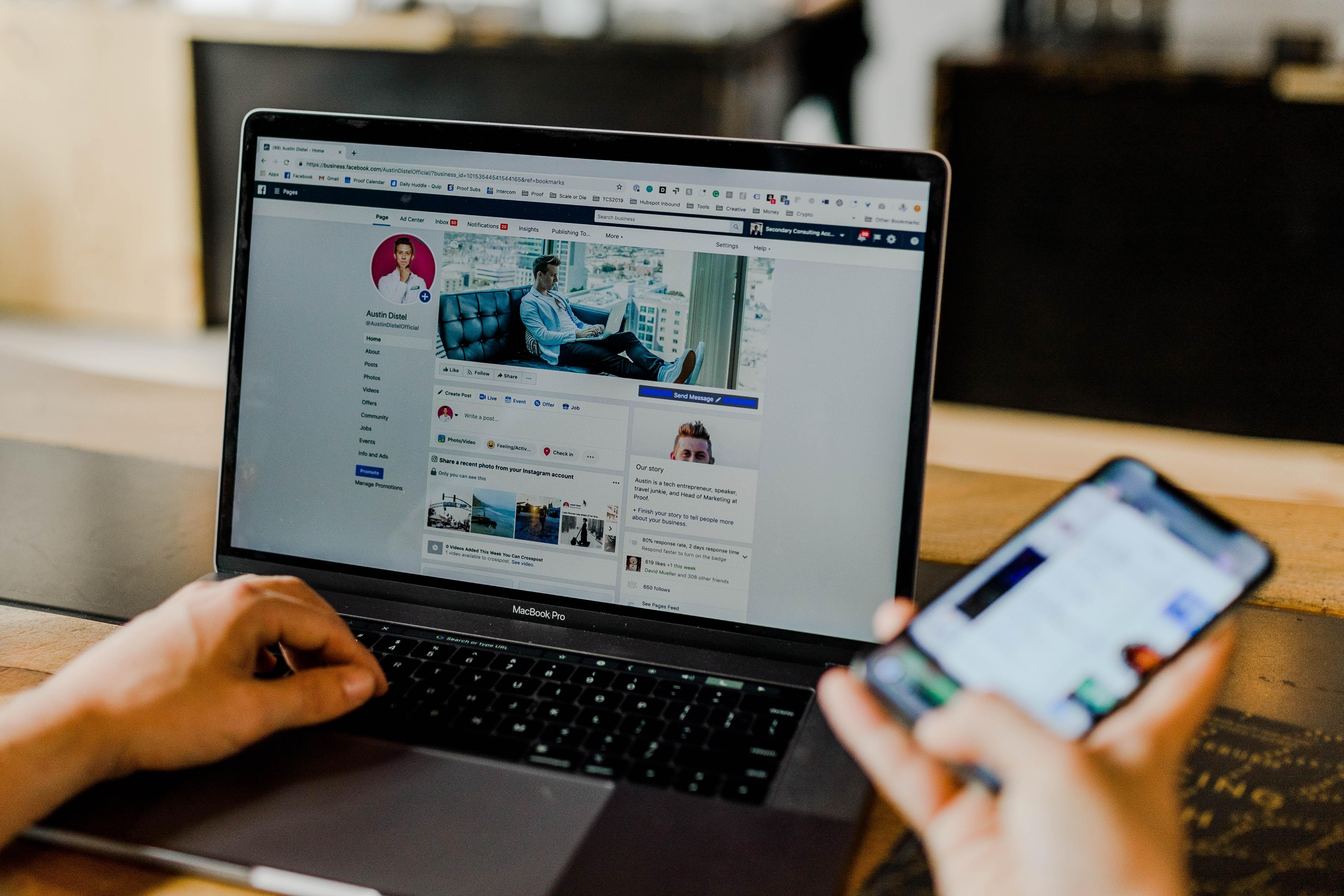 person using facebook on both a laptop computer and mobile phone