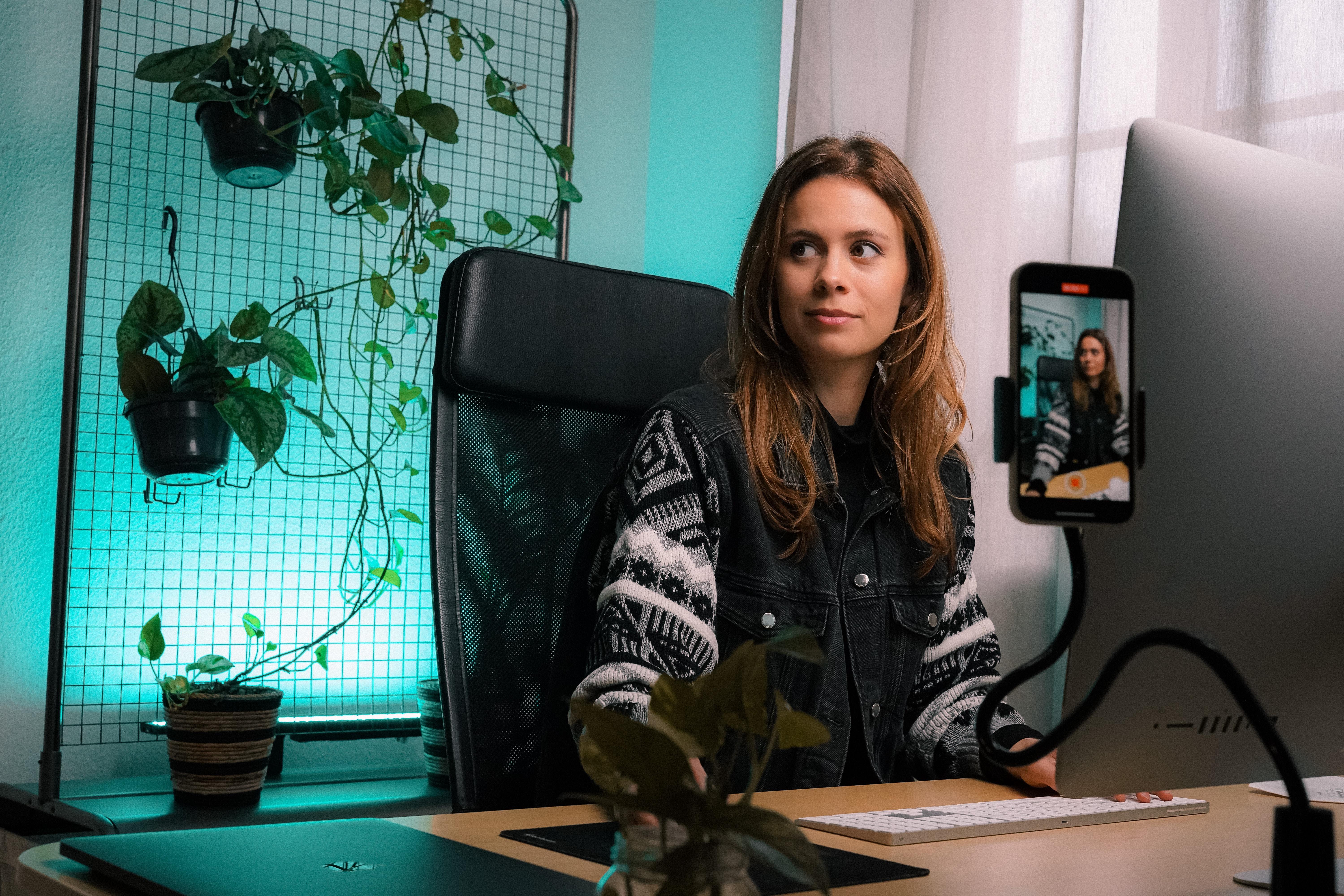 woman sitting in front of computer filming a video