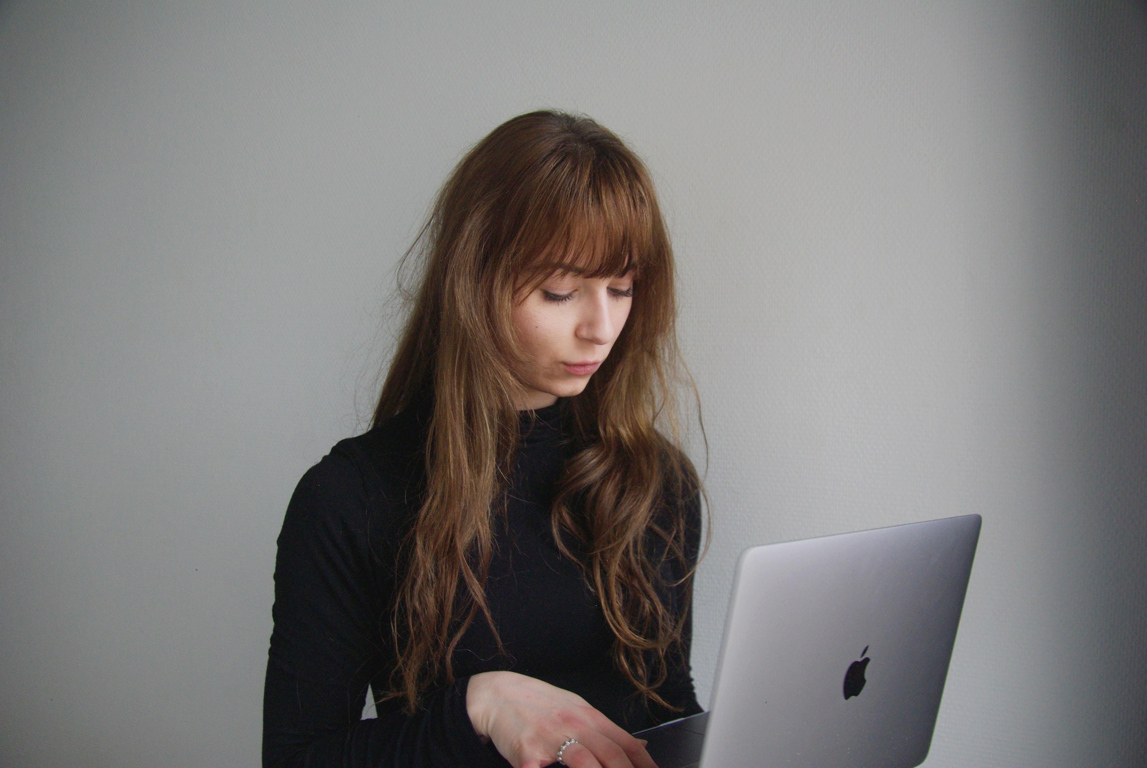 young woman with long brown hair using a laptop computer