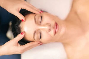 Ozempic Face Before and After Massage: Treatments & Natural Fixes Woman-receiving-face-massage-in-spa-center