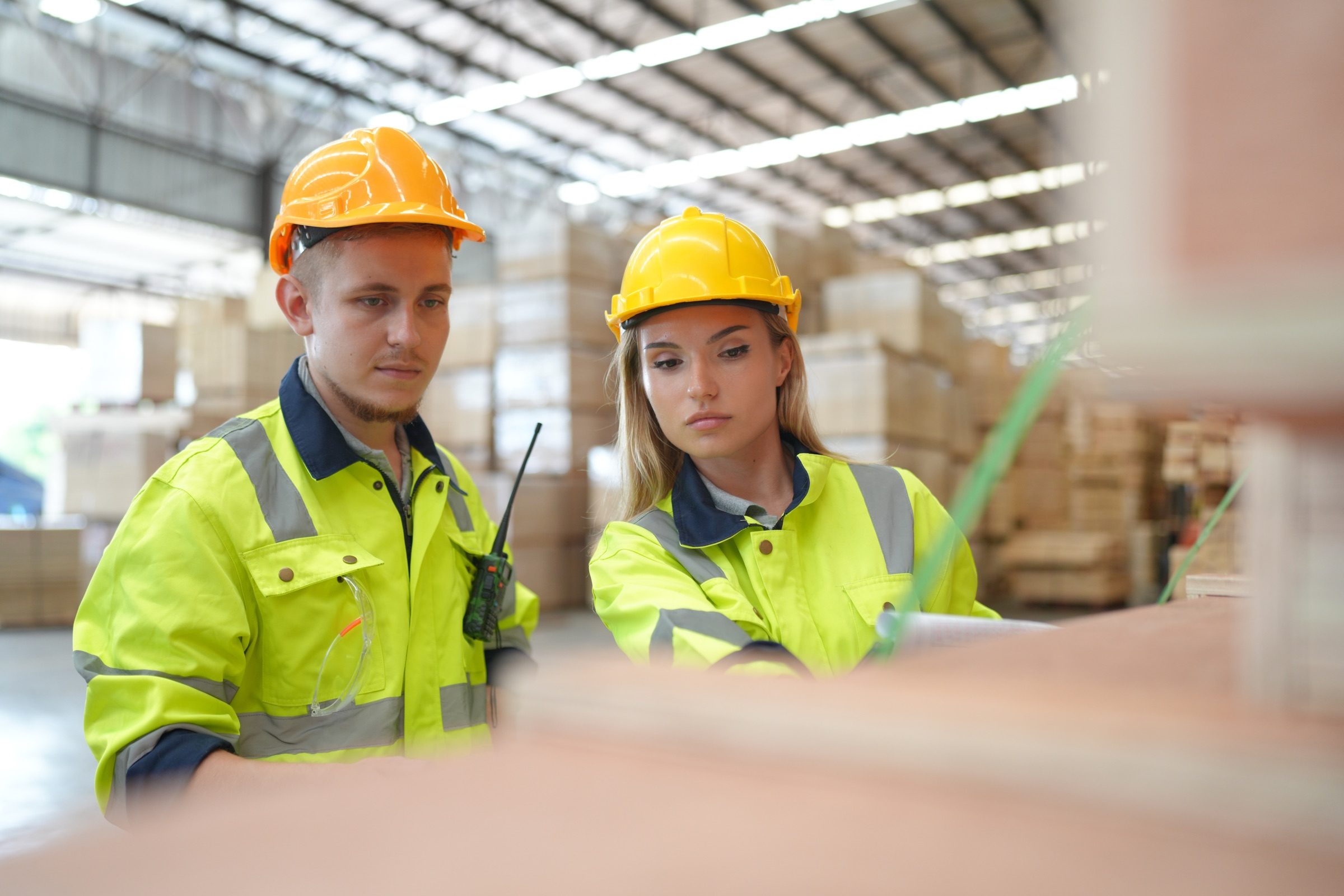 A logistics coordinator working with a digital operations platform beside a distribution center.