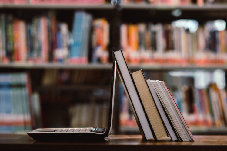 laptop computer and book on workplace in library room,Education