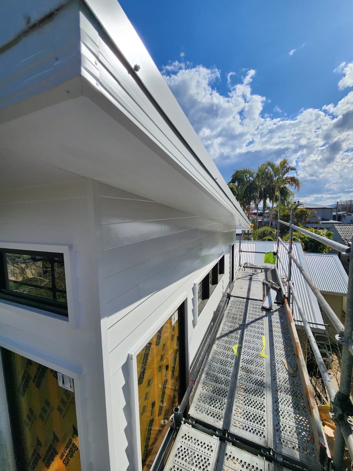 Painters at work on outside coats for a home near the coast