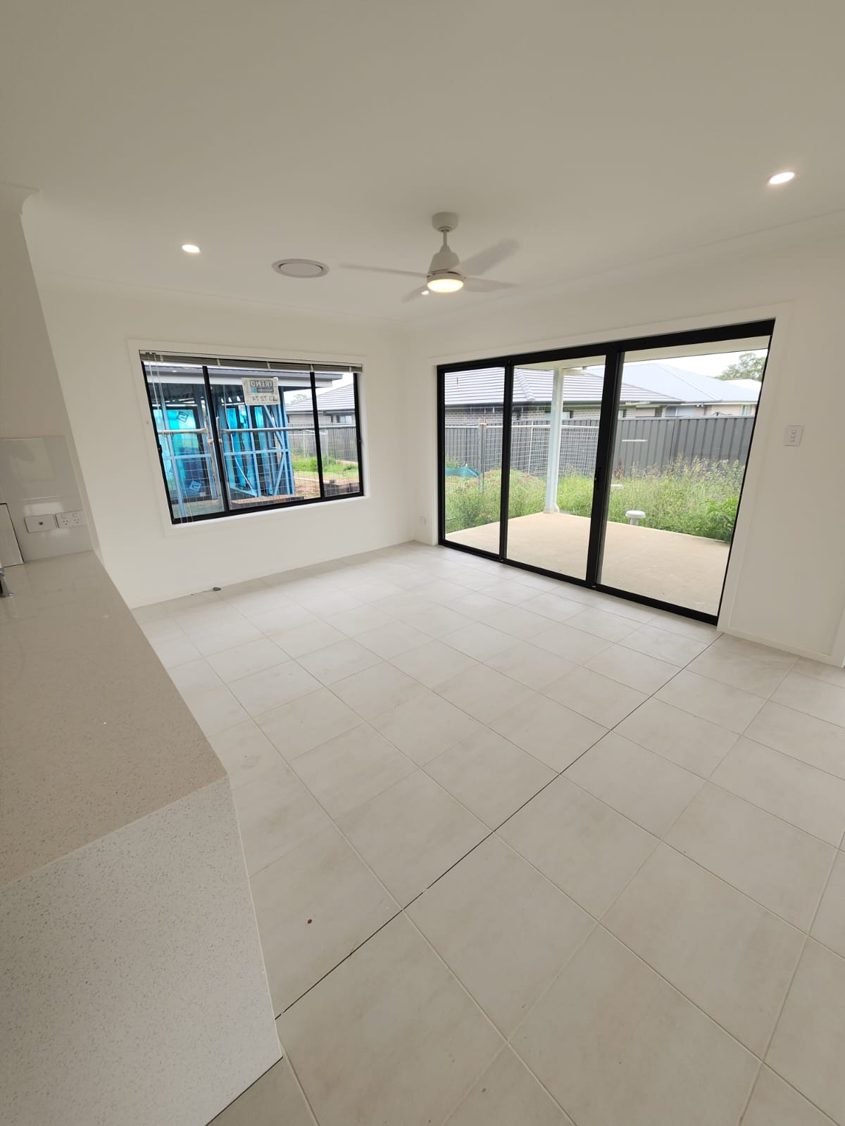 Open living and dining area painted in white with tiled flooring