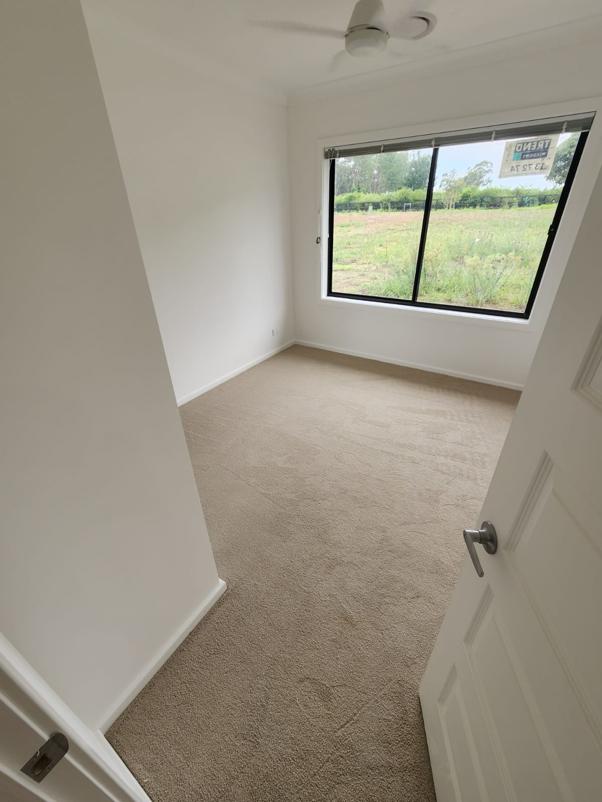 Empty bedroom with freshly painted white walls and carpeted floor