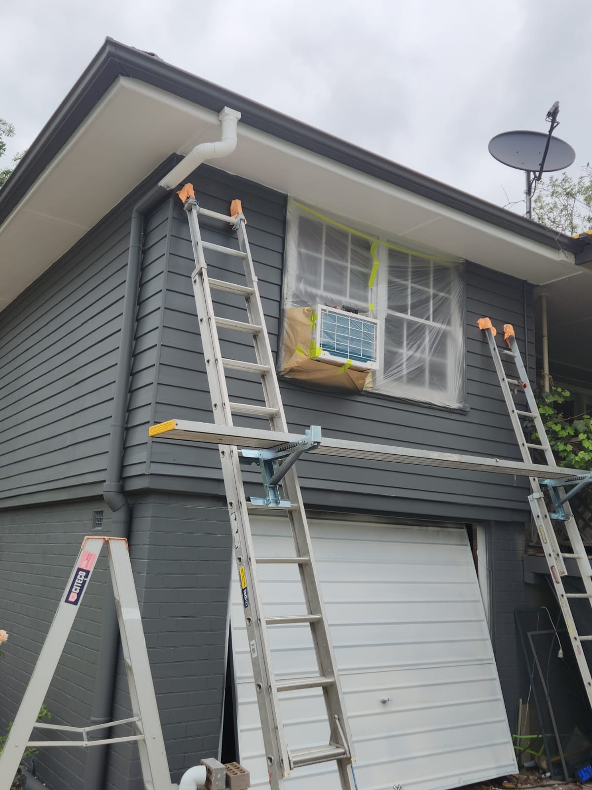 Ladders and planks set up against a Newcastle home during an exterior repaint