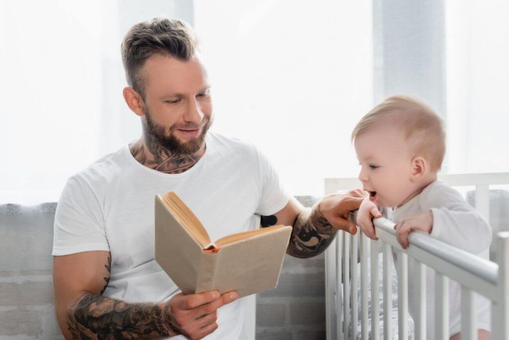 otecko číta knižku nadšenému synčekovi v postieľke