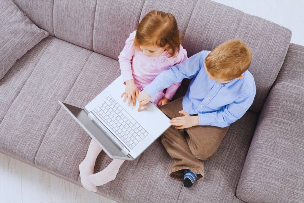 dve deti ťukajú do notebooku