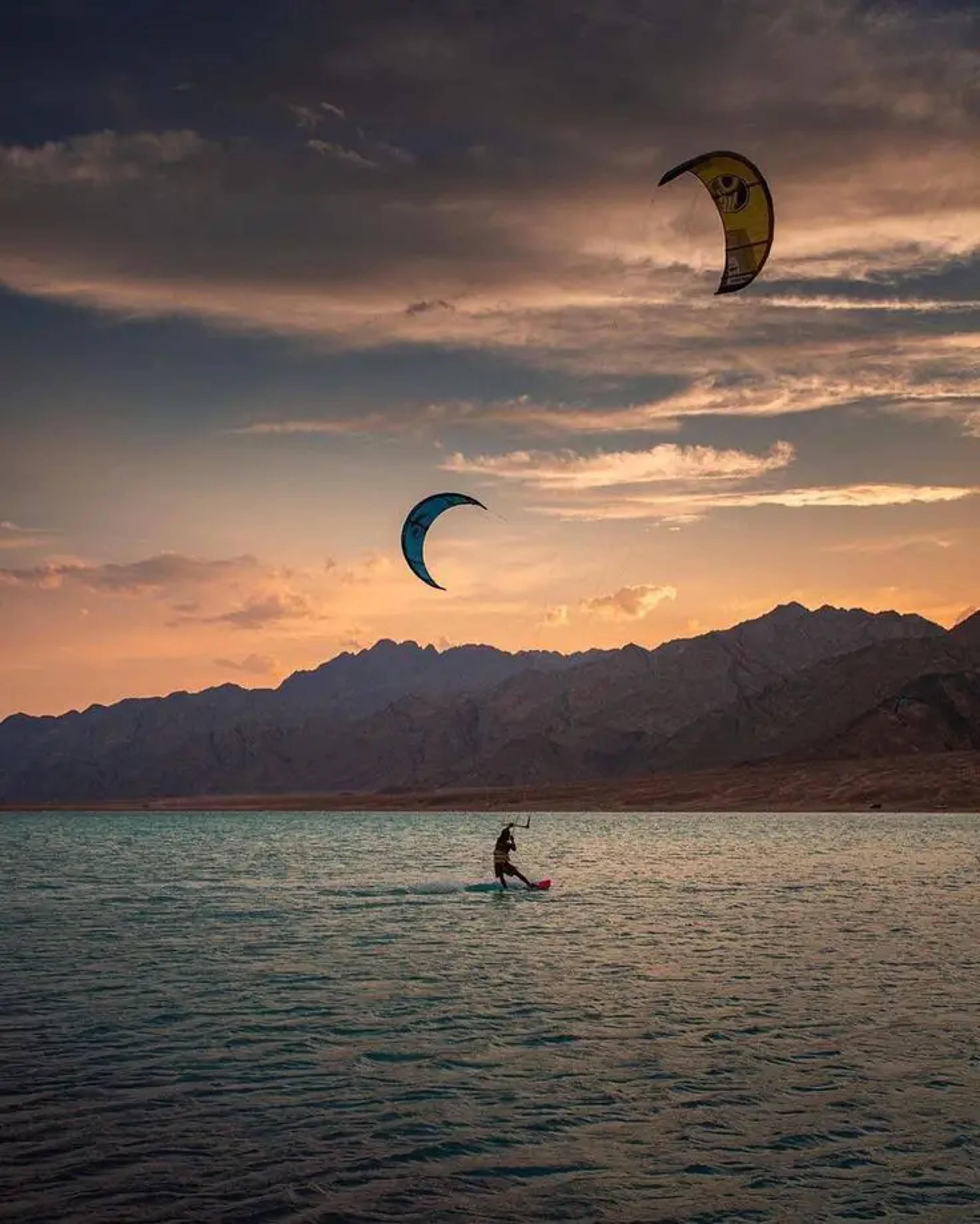 Kitesurfer carving across the flat water lagoon in Dahab