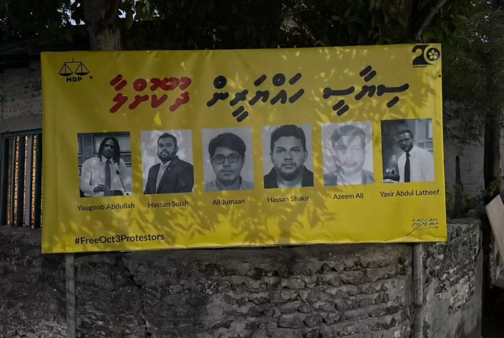 A poster calls for the release of six arrested during the October 3 protest