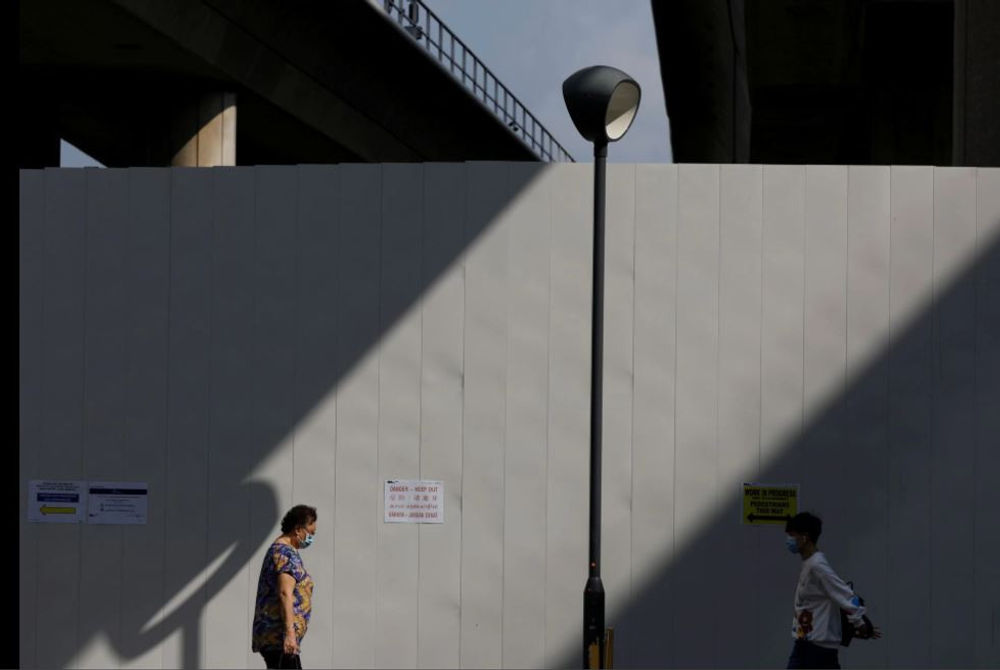 ސިންގަޕޯރުގެ ޓްރެއިން ސްޓޭޝަނެއްގެ ބޭރުން ބަޔަކު މާސްކު އަޅައިގެން ހިނގާފައިދަނީ