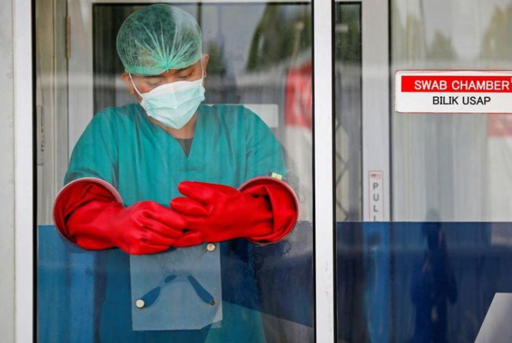 އިންޑޮނޭޝިޔާގެ ސިއްހީ މަސައްކަތްތެރިއެއް ކޮވިޑަށް ޓެސްޓް ކުރުމަށް މީހެއްގެ ސާމްޕަލް ނެގުމަށް މަސައްކަތްކުރަނީ