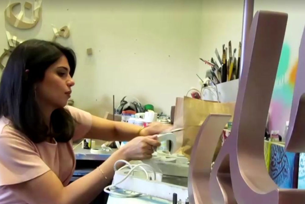 އަރަބި ކެލިގްރަފީގެ މަސައްކަތެއް ކުރަނީ