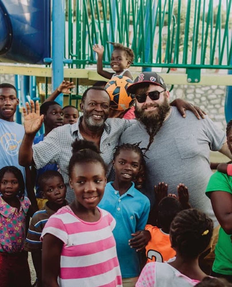 A few adults and children waiving at a playground