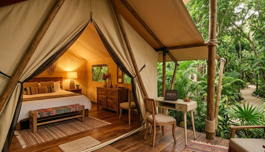 Serena Glamping Tulum: Luxury Jungle Suite | Cancun Airport Transportation Luxury tent interior at Serena Glamping Tulum with bed and desk, destination for Cancun Airport Transportation services.