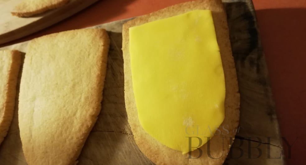 Add the cut out yellow icing to each biscuit