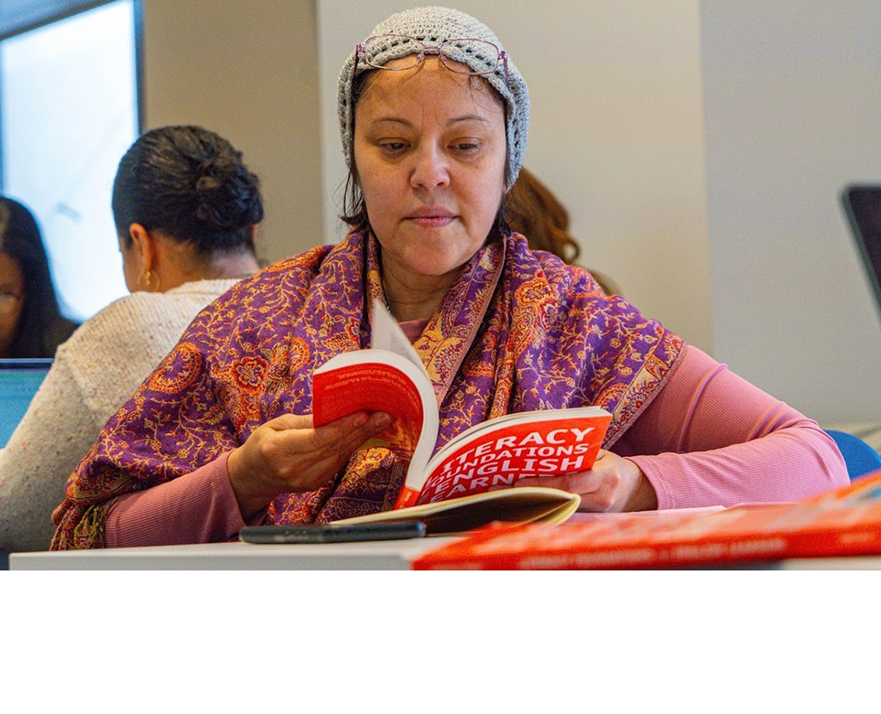 Woman reading a book at a library table