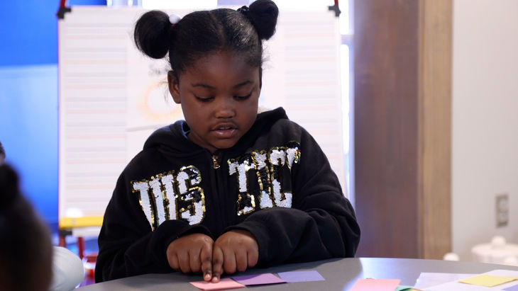 First grader identifying individual sounds using Touch and Say strategy with colored cards