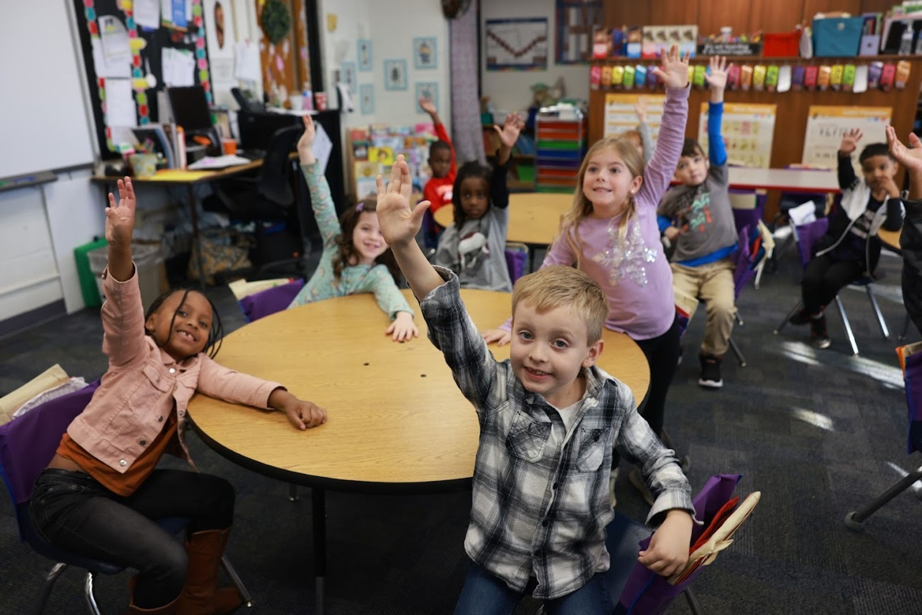 Children raising their hands in a classroom