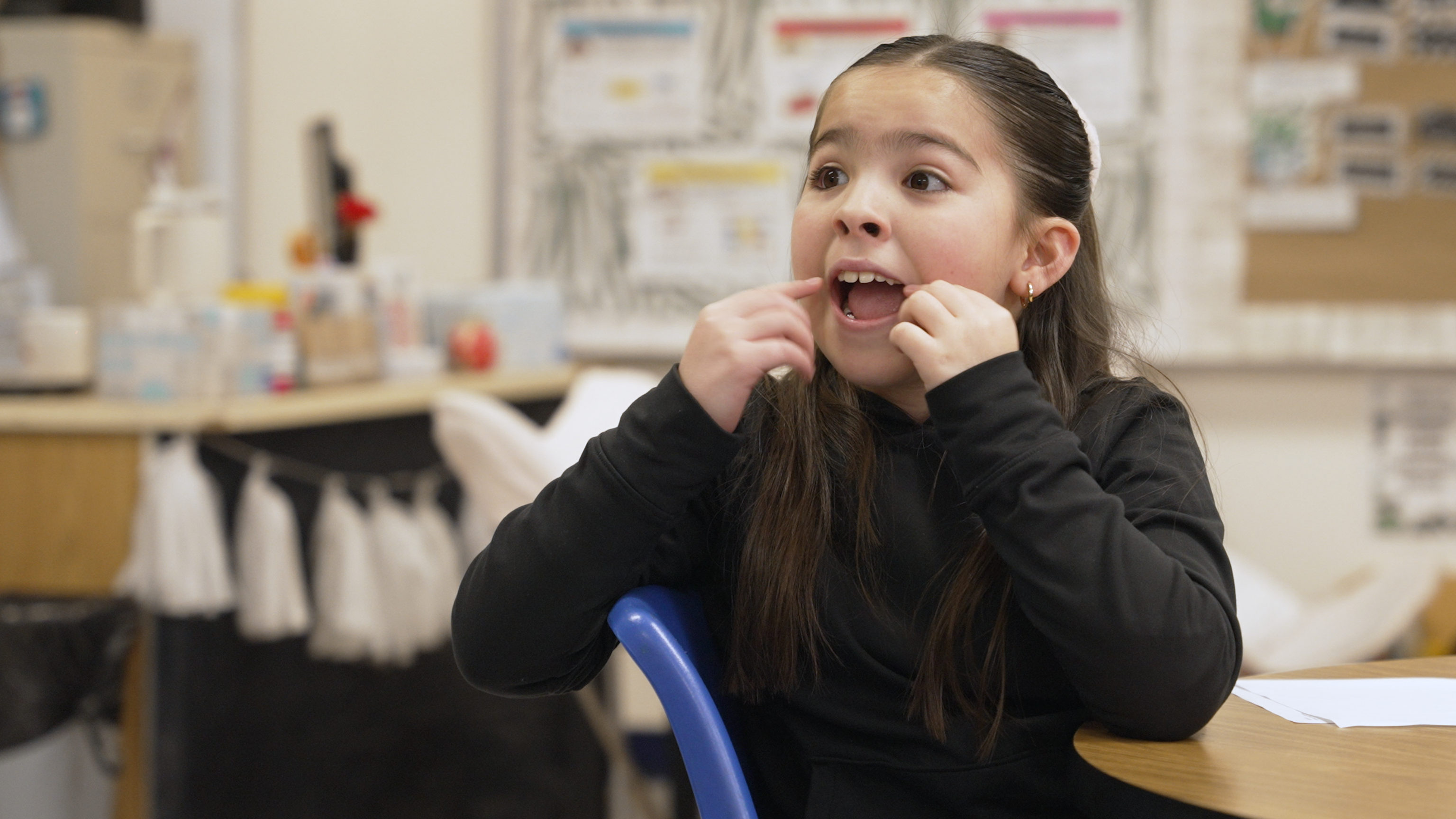 A student opening her mouth to illustrate the short 'o' sound