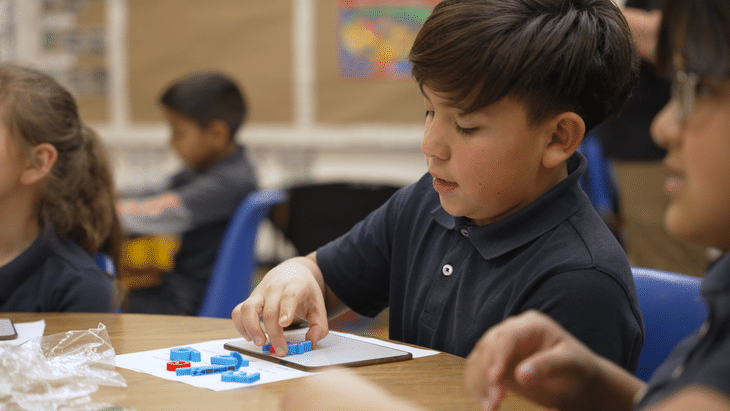 Student practices spelling short vowel words on a magnet board