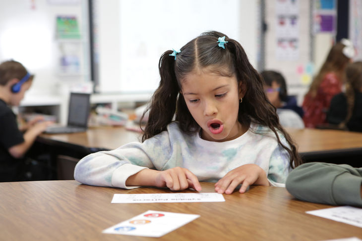 Girl practicing articulation in class using flash cards