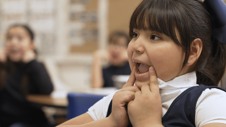 Girl with fingers to her mouth as she learns articulation