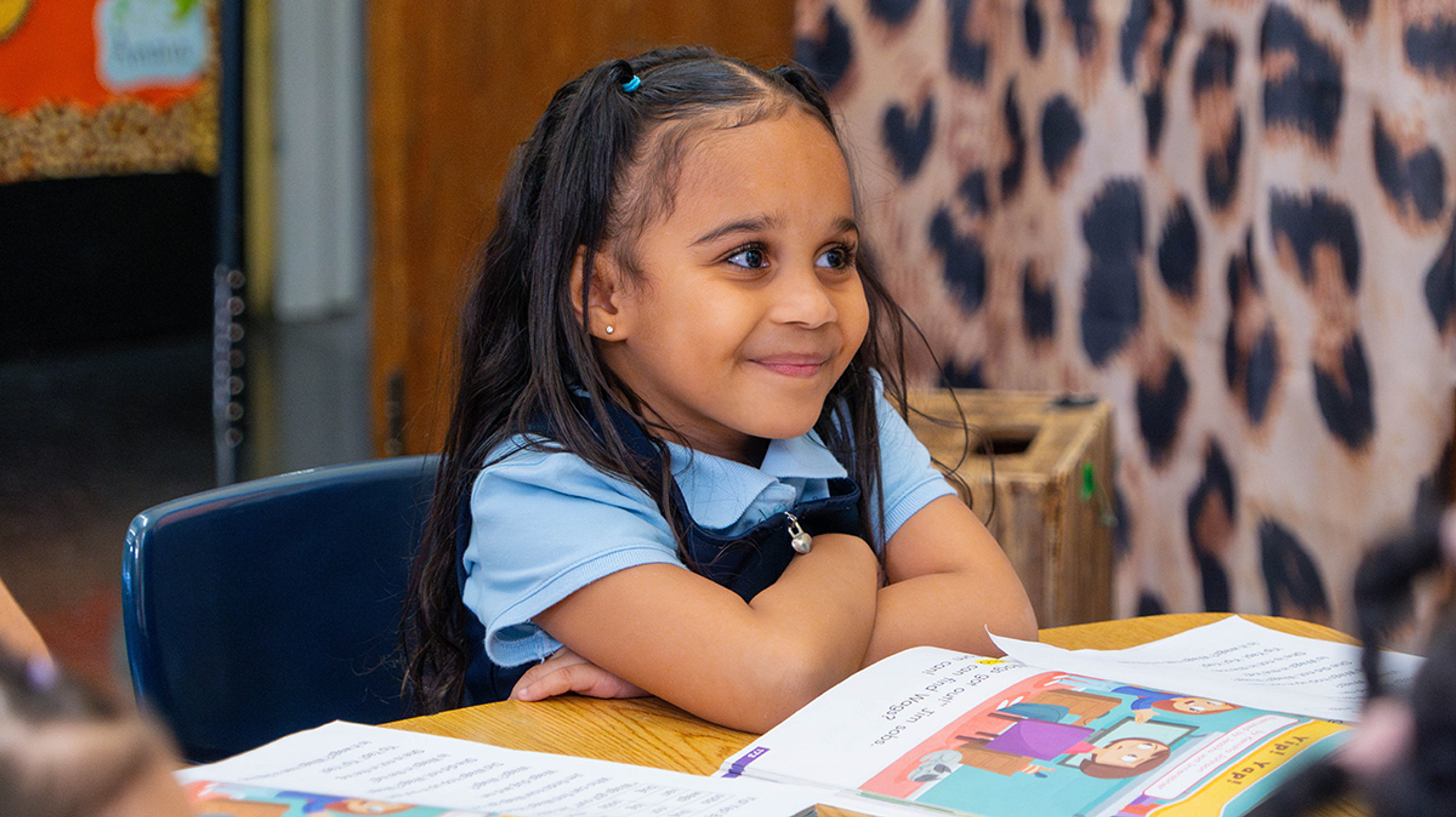 Smiling girl reading book in class