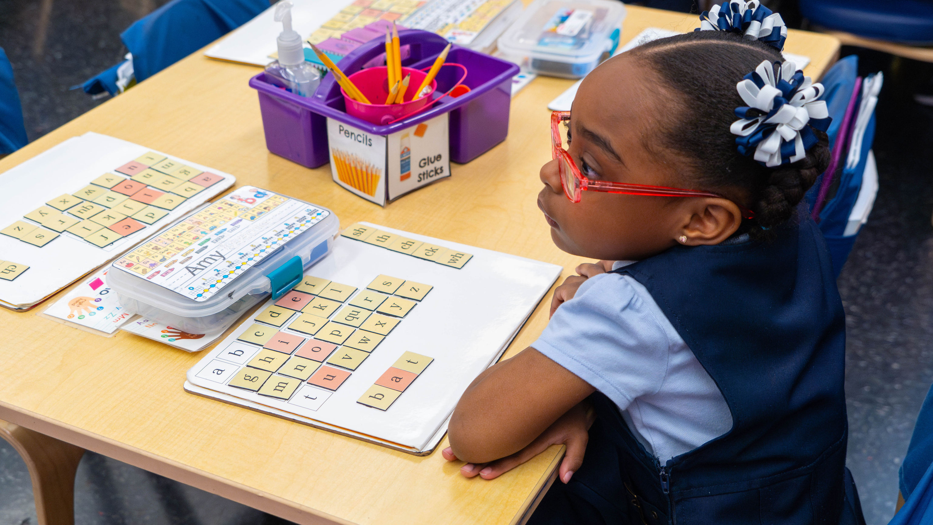 Girl at her desk with syllable tiles