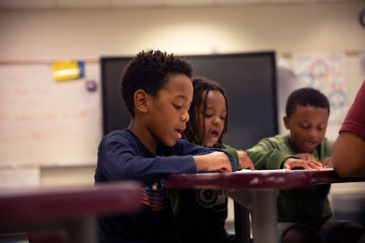 Students reading out loud at their desks