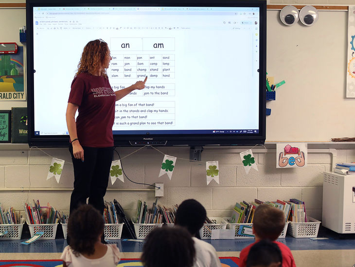 Teach using a smartboard to teach her students about glued sounds.