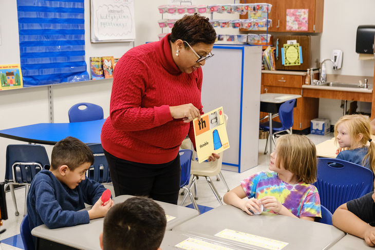 Teacher showing a student a flash card in class